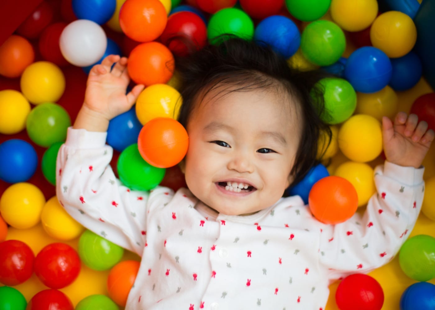  Baby smiling around colorful balls