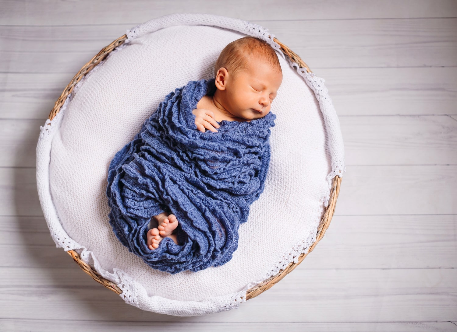Cute newborn baby nestled in a basket for an adorable photoshoot in Singapore