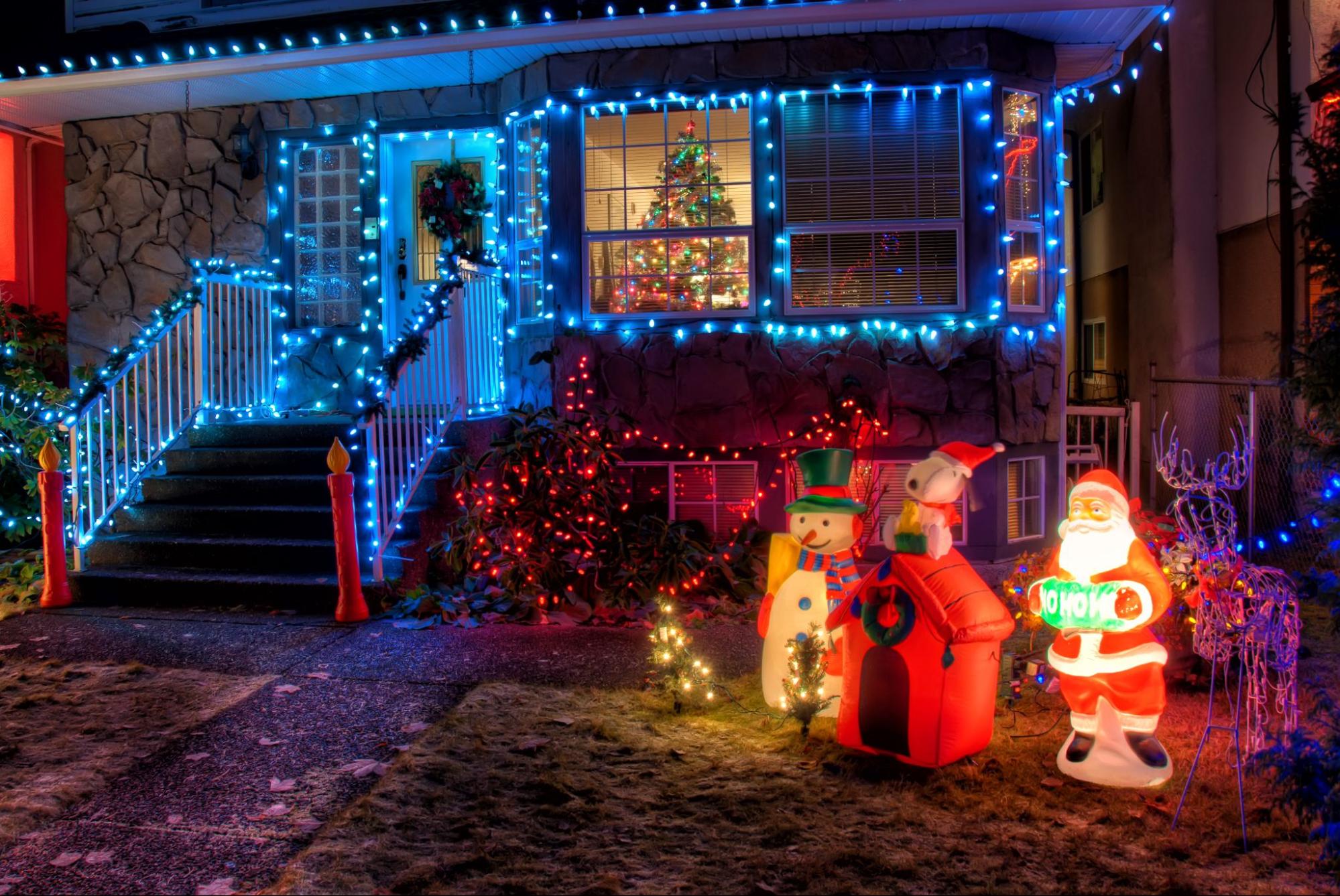 The image depicts a house adorned with vibrant Christmas lights, creating a festive ambiance