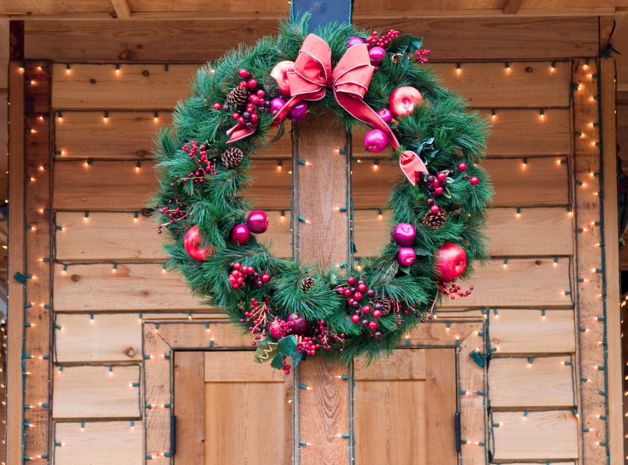 Christmas wreath with lights adorning wooden porch
