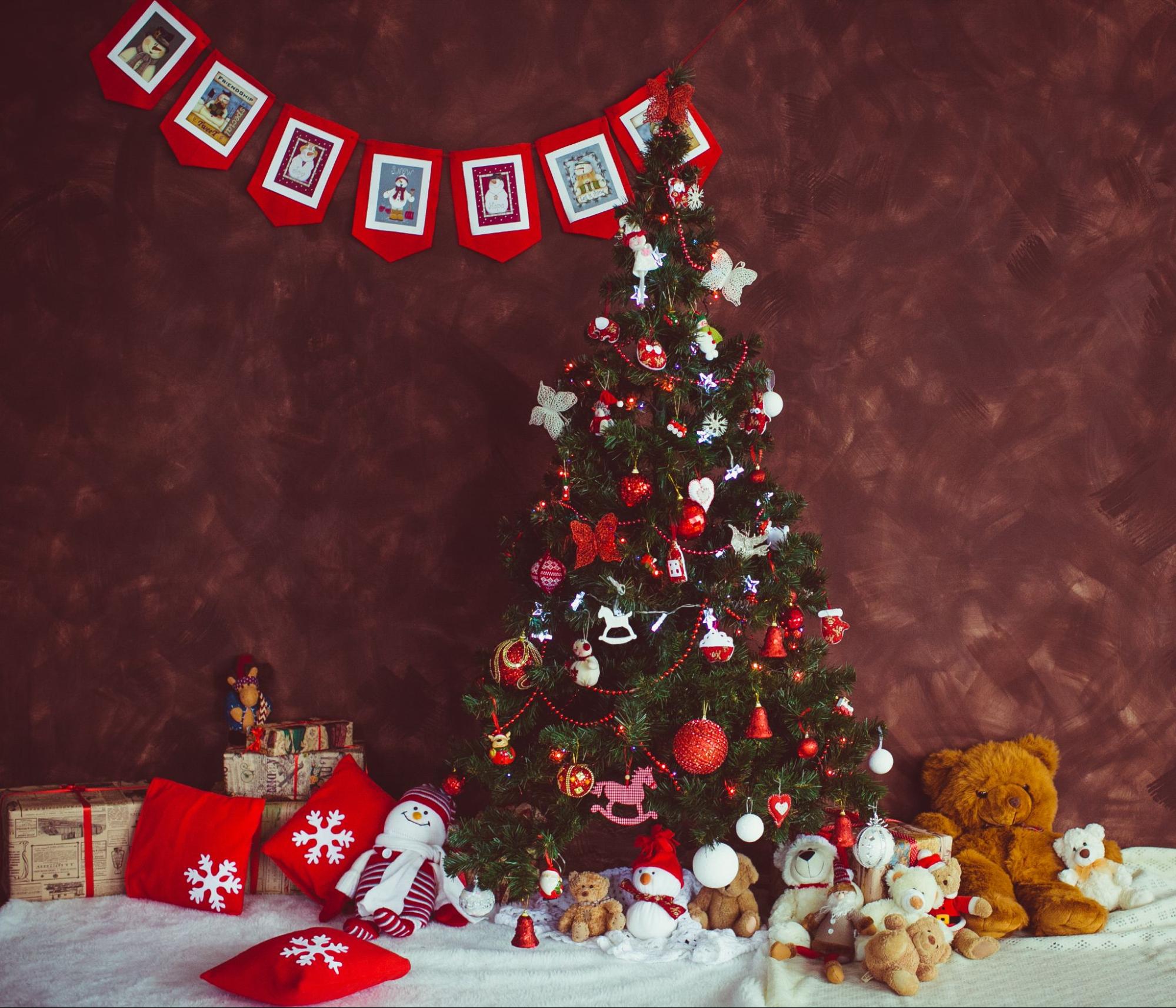 Festive Christmas tree and presents on a warm brown backdrop.