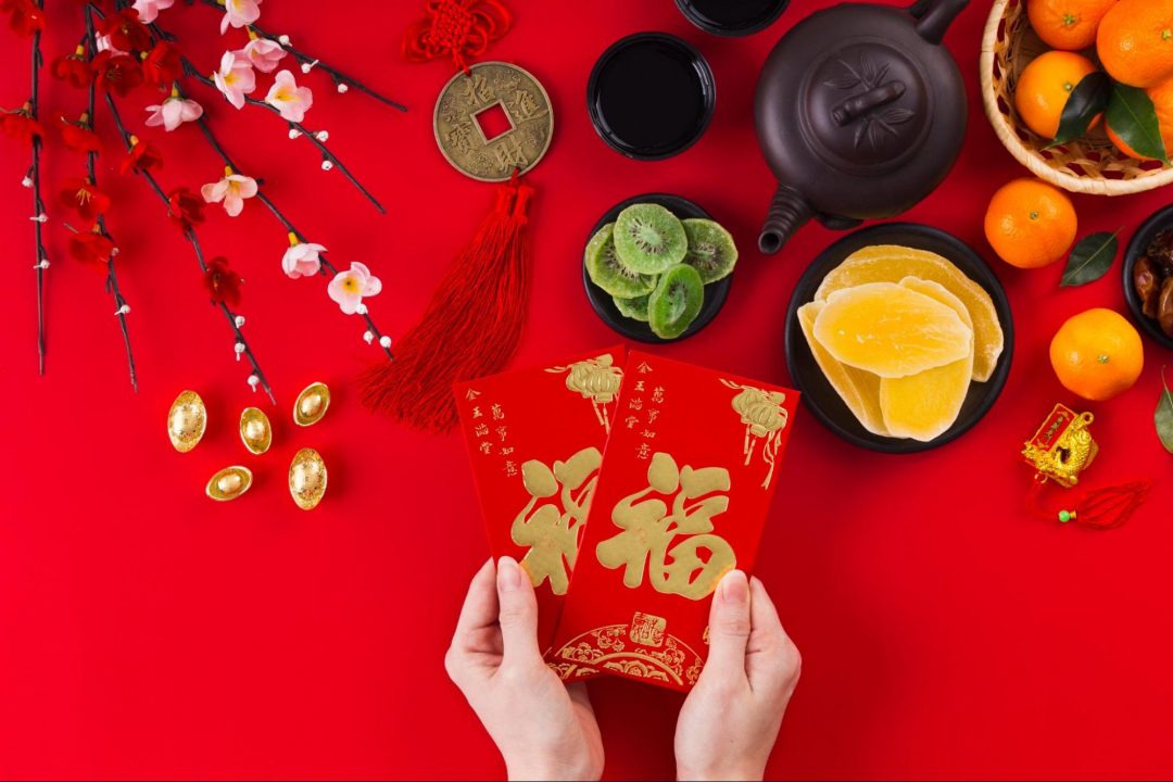 Chinese New Year red card, characters, and oranges on red background—perfect gifts for Lunar New Year celebrations.