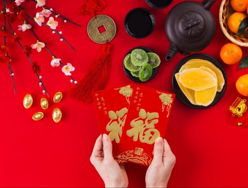 Chinese New Year red card, characters, and oranges on red background—perfect gifts for Lunar New Year celebrations.