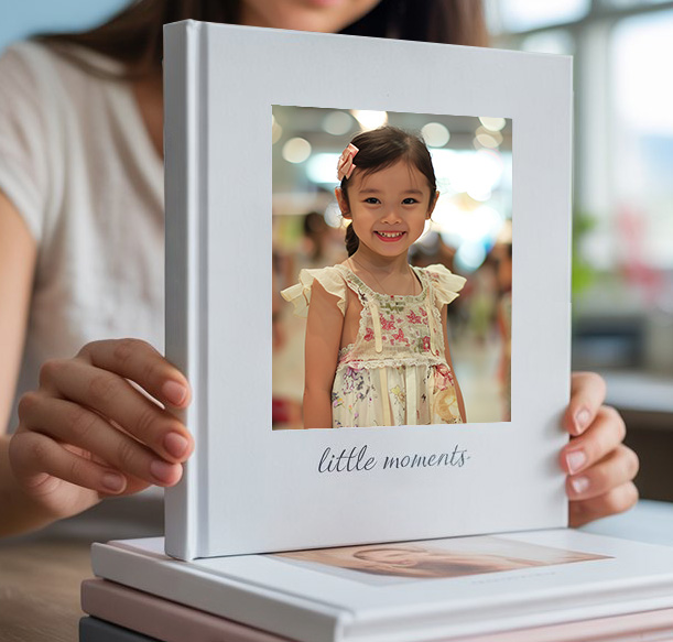 Person holding a personalised family photo book with a child's portrait on the cover